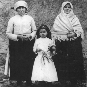 Dobový odev, rok 1922. Na fotke dieťa Anna Mikušová (Halinárová), hore vľavo jej mama Anna Mikušová.
